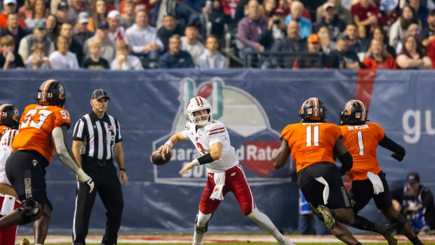 Chase Wolf throwing the ball side arm against Oklahoma State in the Guaranteed Rate Bowl.